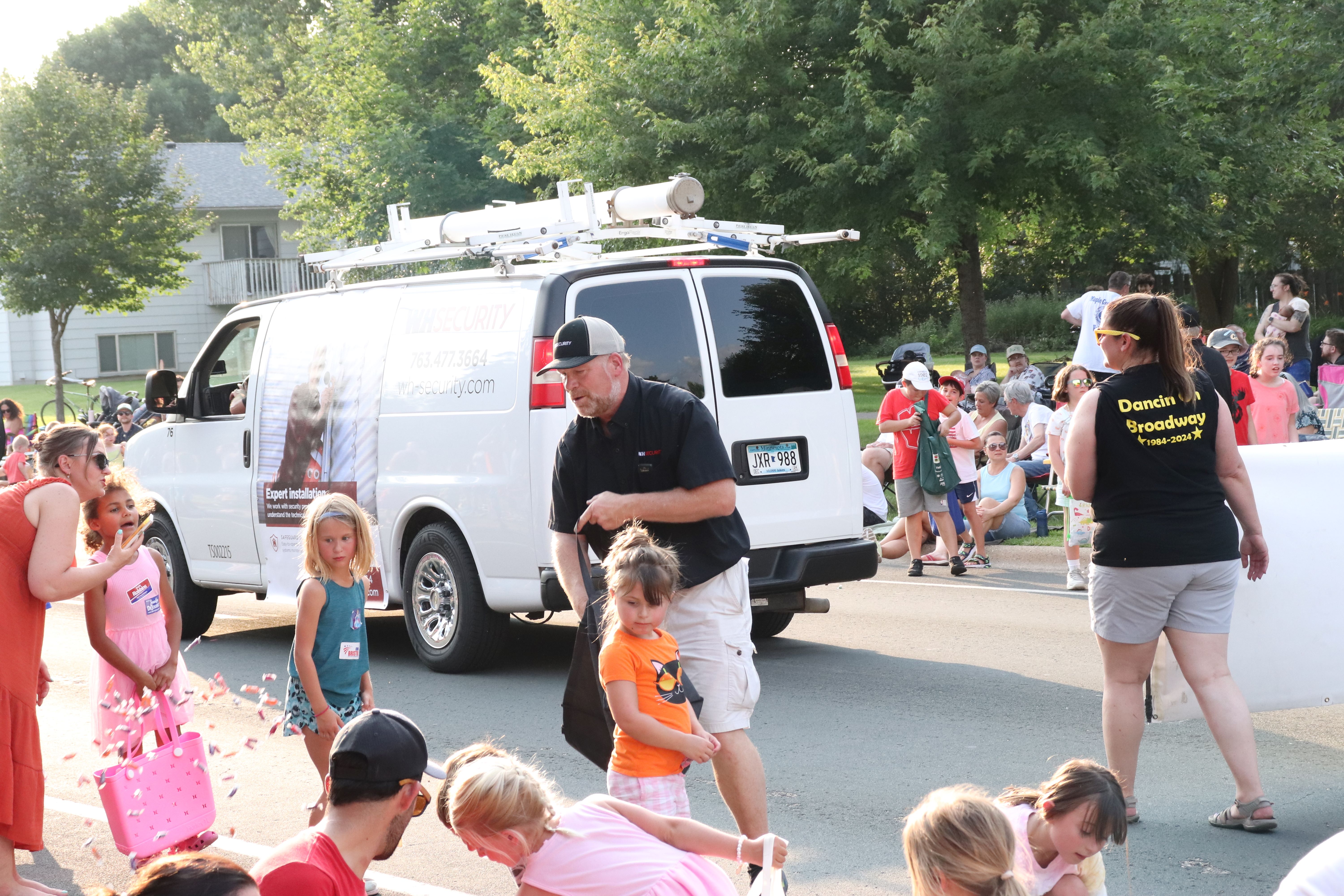 Security technician handing out candy at parade