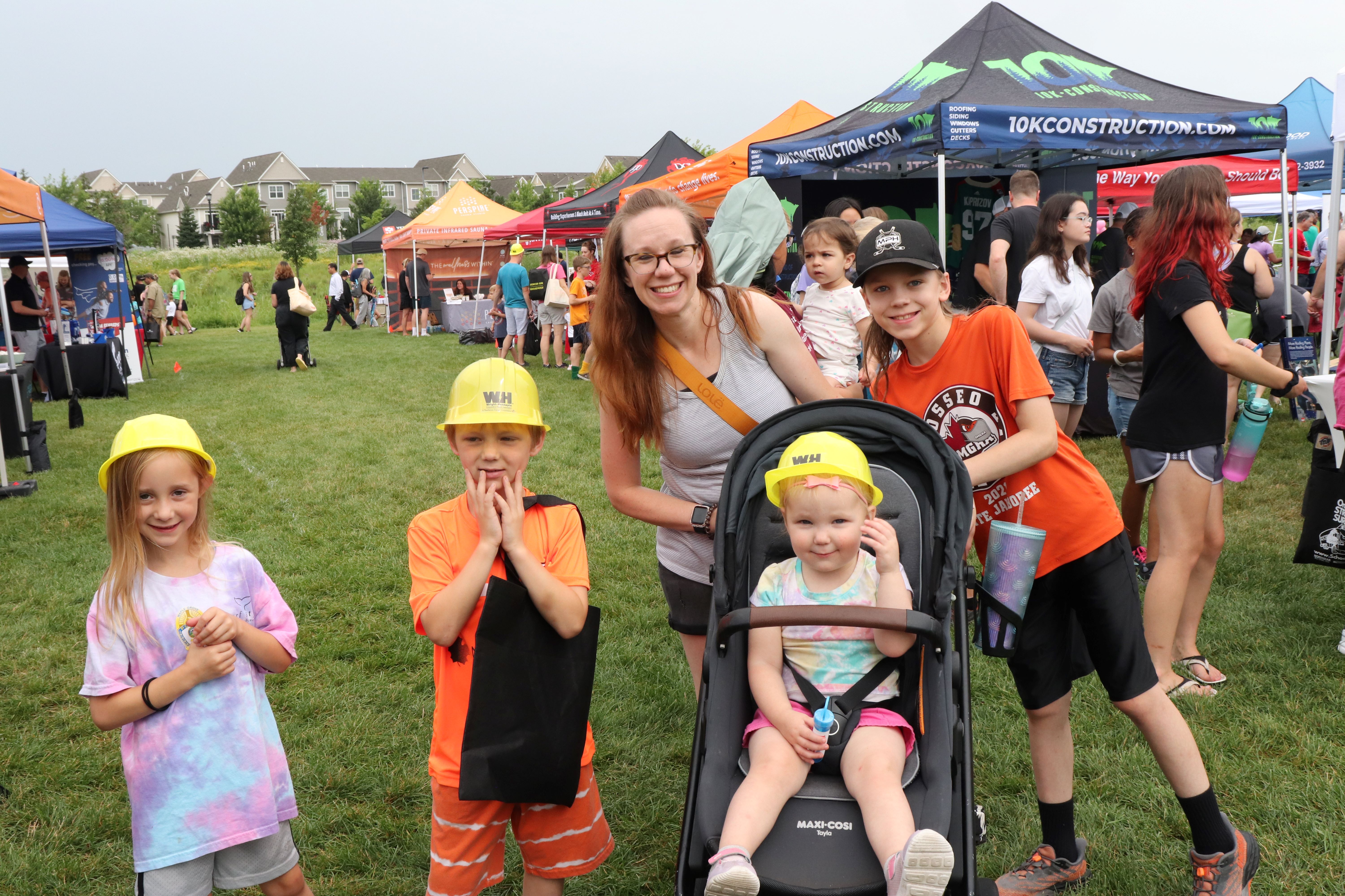 family of five standing outside booth at fair